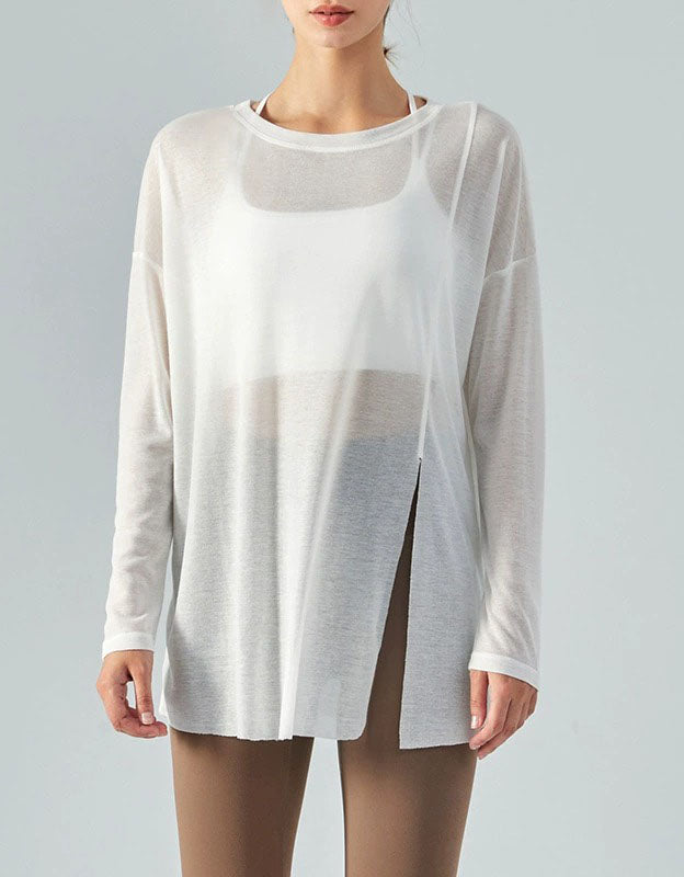 White sheer long-sleeve top worn by a model on a gray background