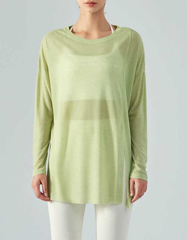 Person wearing a light green long-sleeve top on a plain background