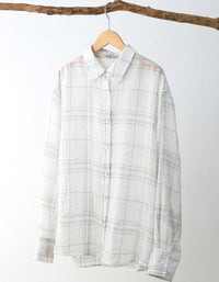 Plaid shirt on a hanger against a white background