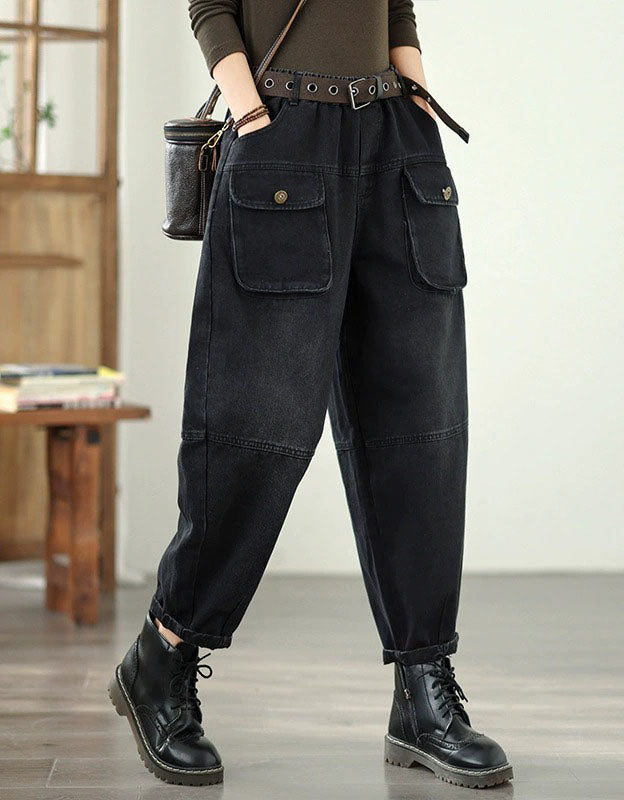 Person wearing black cargo pants with multiple pockets in a room.