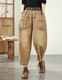 Person wearing brown cargo pants with a belt and brown shoes in a room with wooden furniture.