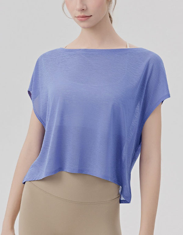 Woman wearing a blue top and beige pants on a light gray background