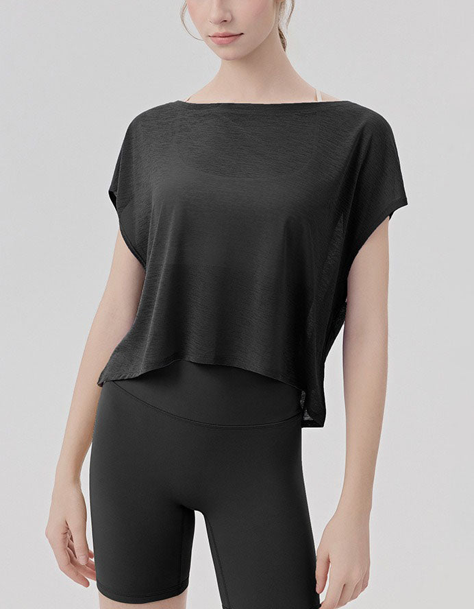 Person wearing a black top and black shorts on a light gray background