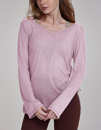 Woman wearing a pink long-sleeve top against a gray background