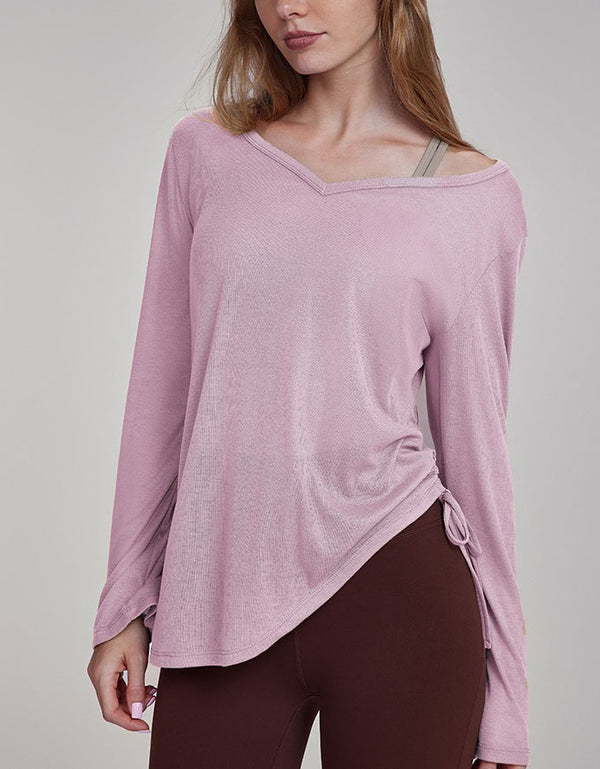 Woman wearing a pink long-sleeve top with a gray background