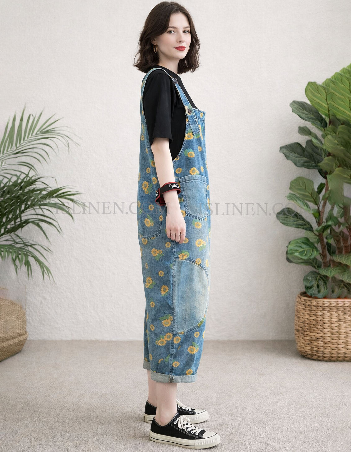 Side view of large front pocket detail on women’s loose-fit denim overalls 