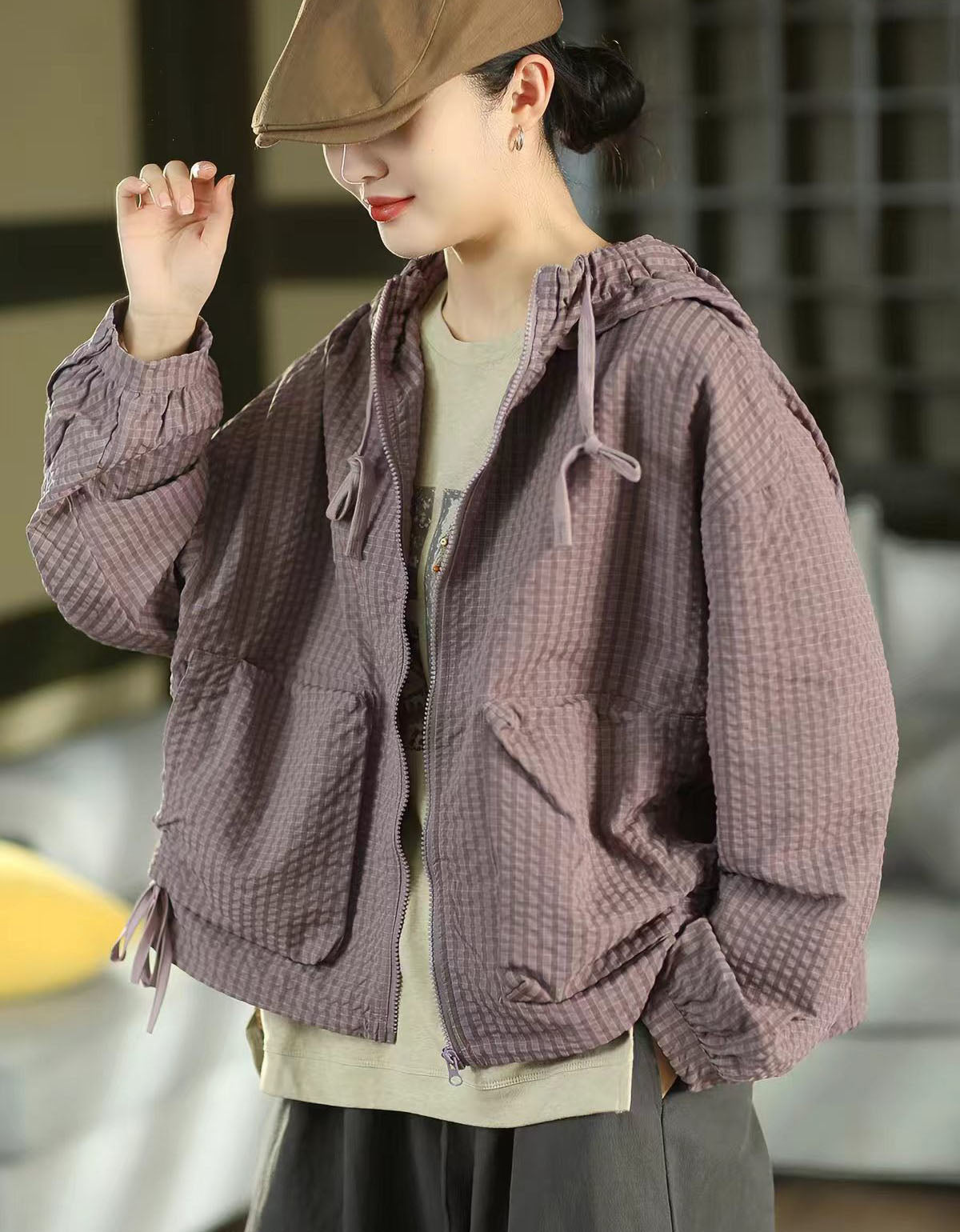 Woman wearing an olive green checkered hooded zip-up casual jacket with a relaxed fit.