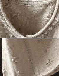 Close-up of floral detailing on pink women's knit cardigan
