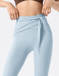 Light blue ribbed leggings with a tie detail on a white background close-up