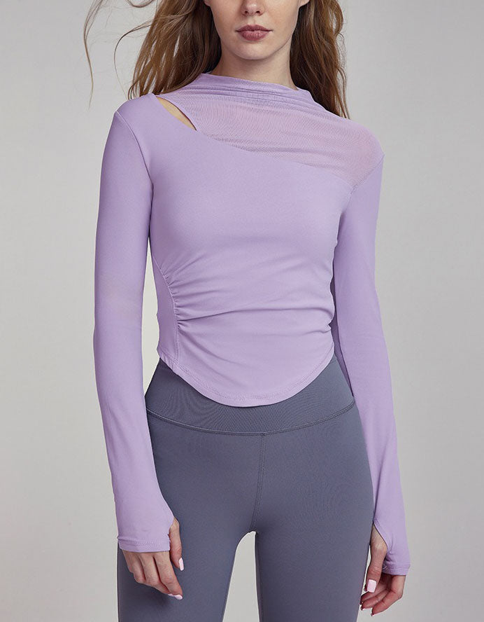 Person wearing a purple long-sleeve athletic top and gray leggings on a plain background