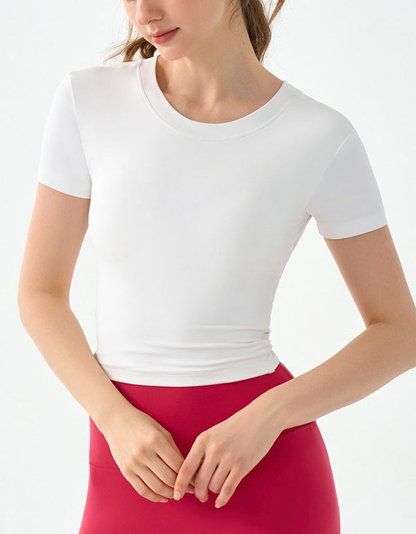 Person wearing a white short-sleeve top and red pants on a light gray background