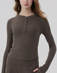 Woman wearing a brown long-sleeve henley shirt on a white background