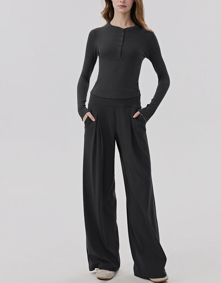 Person wearing a black long-sleeve top and wide-leg pants on a white background