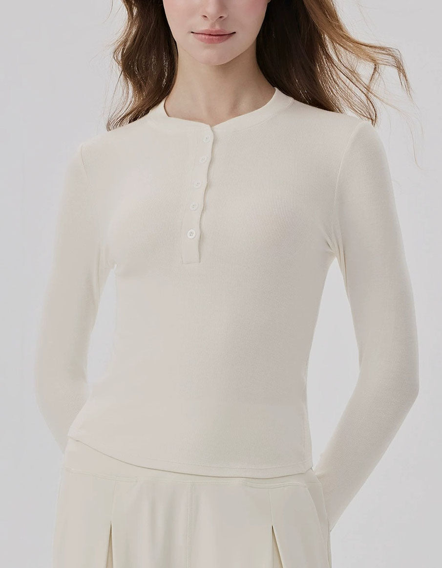 Woman wearing a cream-colored long-sleeve top against a white background