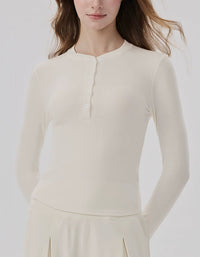 Woman wearing a cream-colored long-sleeve top against a white background