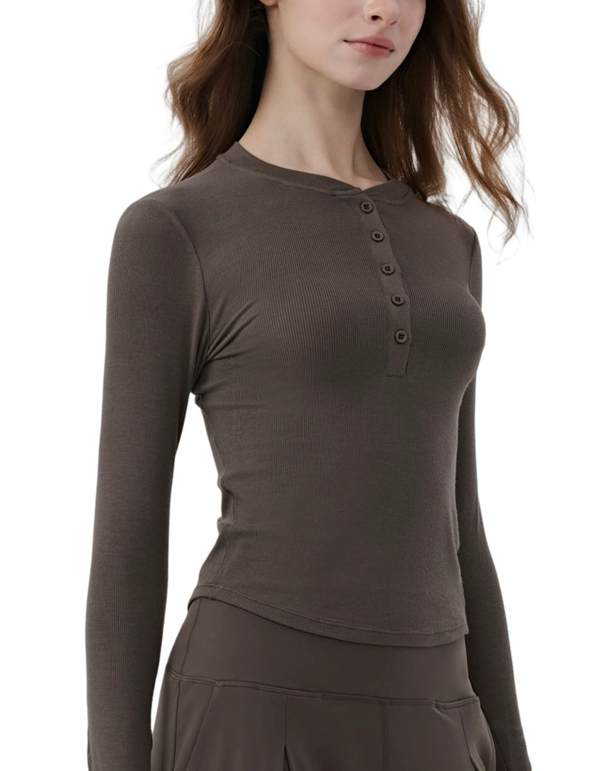 Woman wearing a brown long-sleeve top with buttons on a white background side view