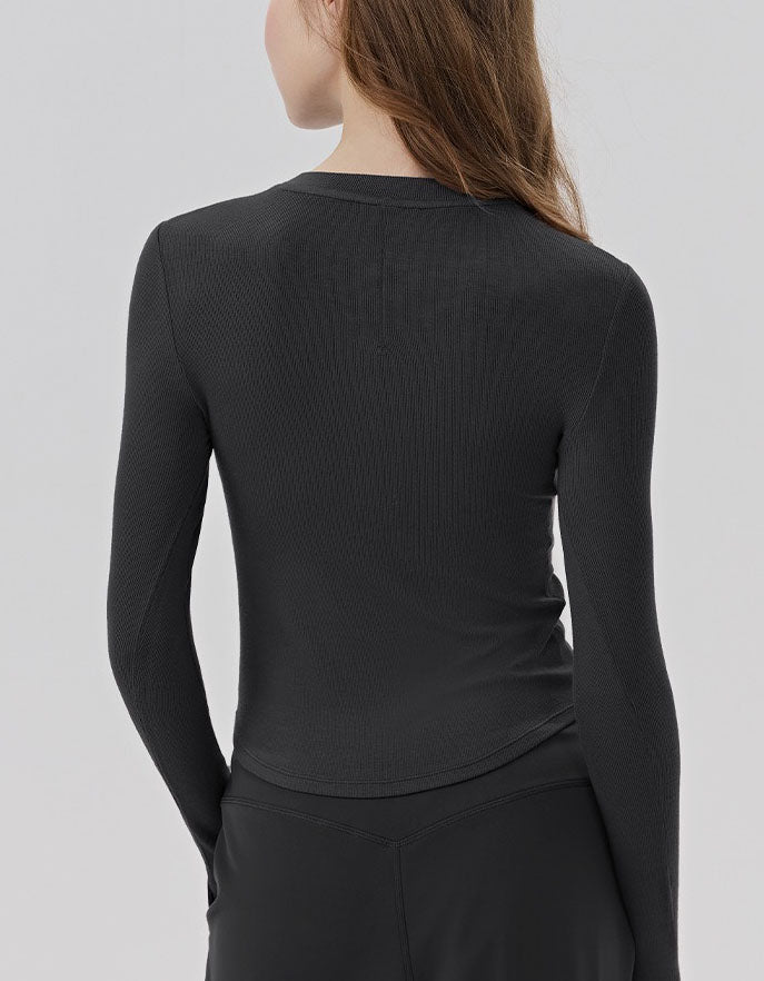 Person wearing a black long-sleeve top against a light gray background back view