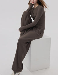 Person wearing a coffee outfit sitting on a white cube against a light gray background