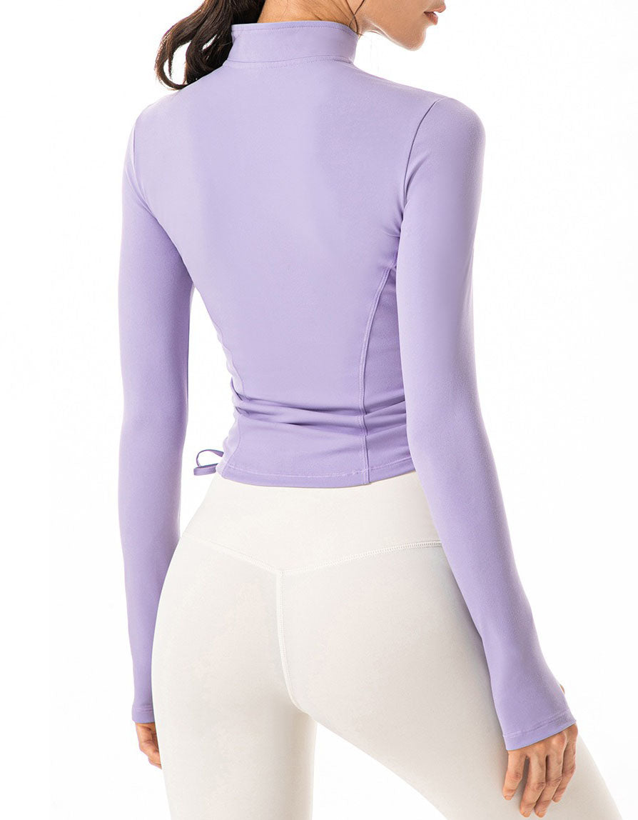 Woman wearing a purple long-sleeve top and white pants on a white background