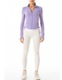 Person wearing a light purple zip-up jacket and white pants on a white background