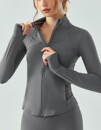 Woman wearing a gray athletic jacket on a light gray background