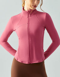 Pink long-sleeve athletic jacket worn by a person on a light gray background