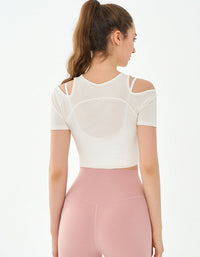 Woman wearing a white crop top and pink leggings on a white background