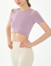 Person wearing a purple crop top and white pants on a plain background