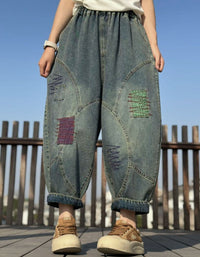 Woman wearing boho patchwork baggy wide leg denim pants with elastic waist, barrel legs and rolled cuffs