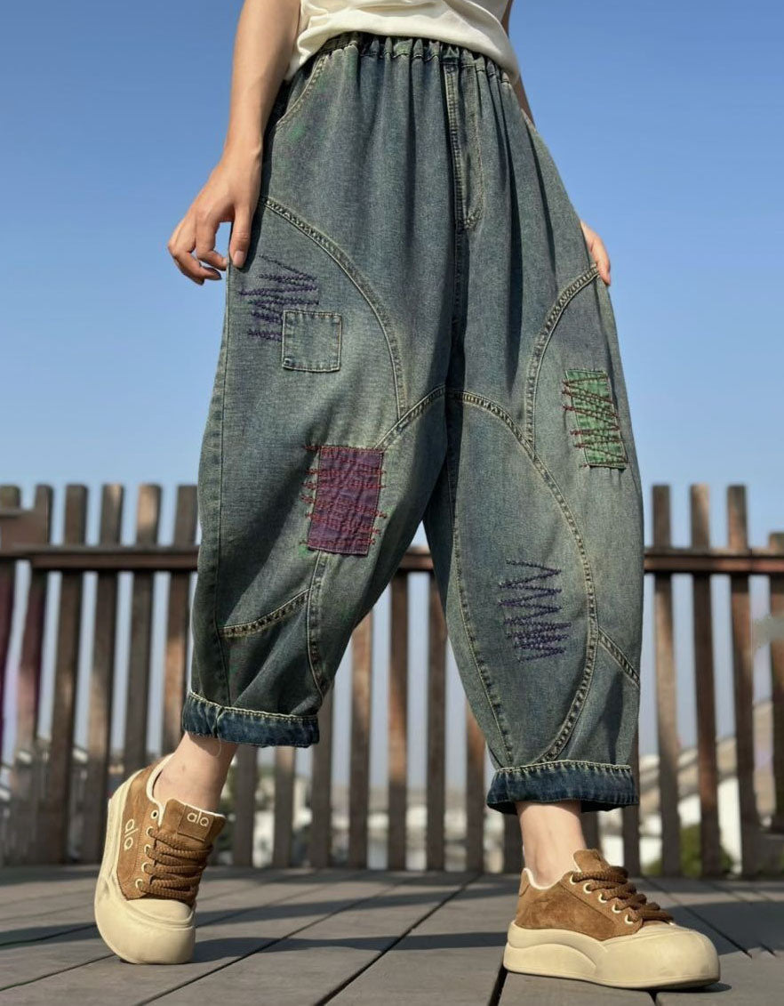 Side view of women’s patchwork baggy denim pants showing curved seams and colorful stitched patches