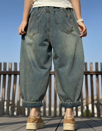 Back view of relaxed barrel leg patchwork denim pants with elastic waistband and cuffed hems