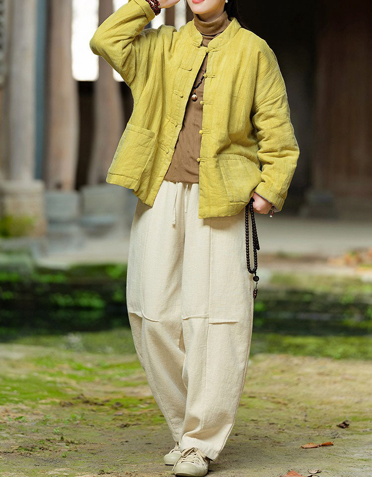 Linen color pants with a relaxed silhouette and rolled ankle cuffs, styled with brown casual shoes.