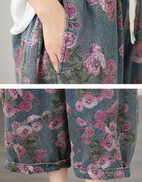 Close-up of pink rose floral print on washed denim fabric pants