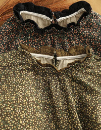 Close-up of a vintage-style floral dress with a ruffled collar and gathered bodice, featuring a dense small floral print in olive green, cream, and muted red tones.