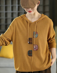 Women's relaxed fit hooded knit sweater in mustard yellow with patchwork front details