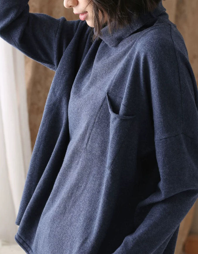 Side view of a women’s blue relaxed fit high neck sweater