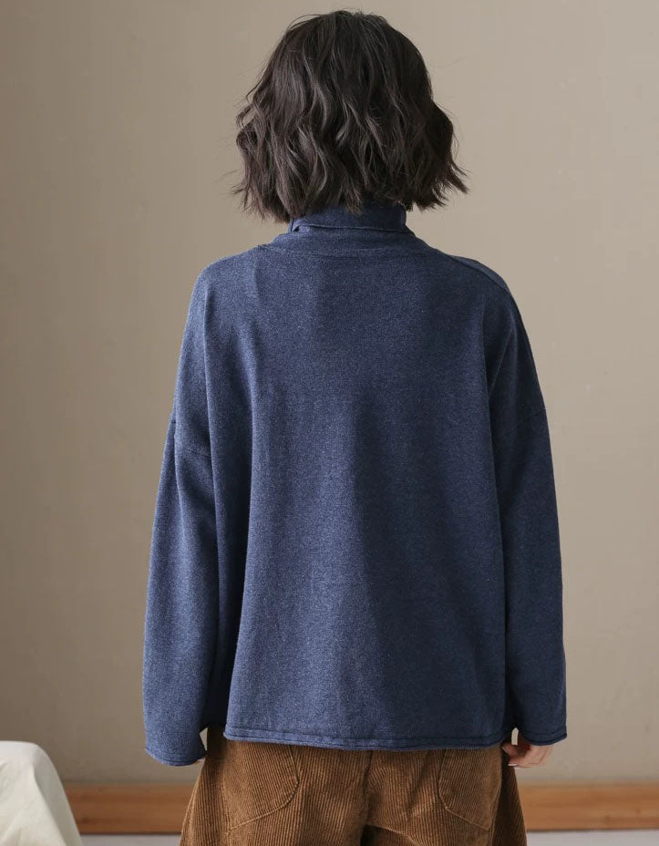 Back view of a women’s blue relaxed fit high neck sweater