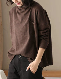 Women’s brown turtleneck top styled with black casual trousers