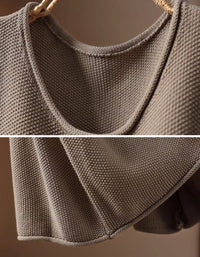 Woman wearing a relaxed taupe vintage graphic knit vest over a white collared shirt