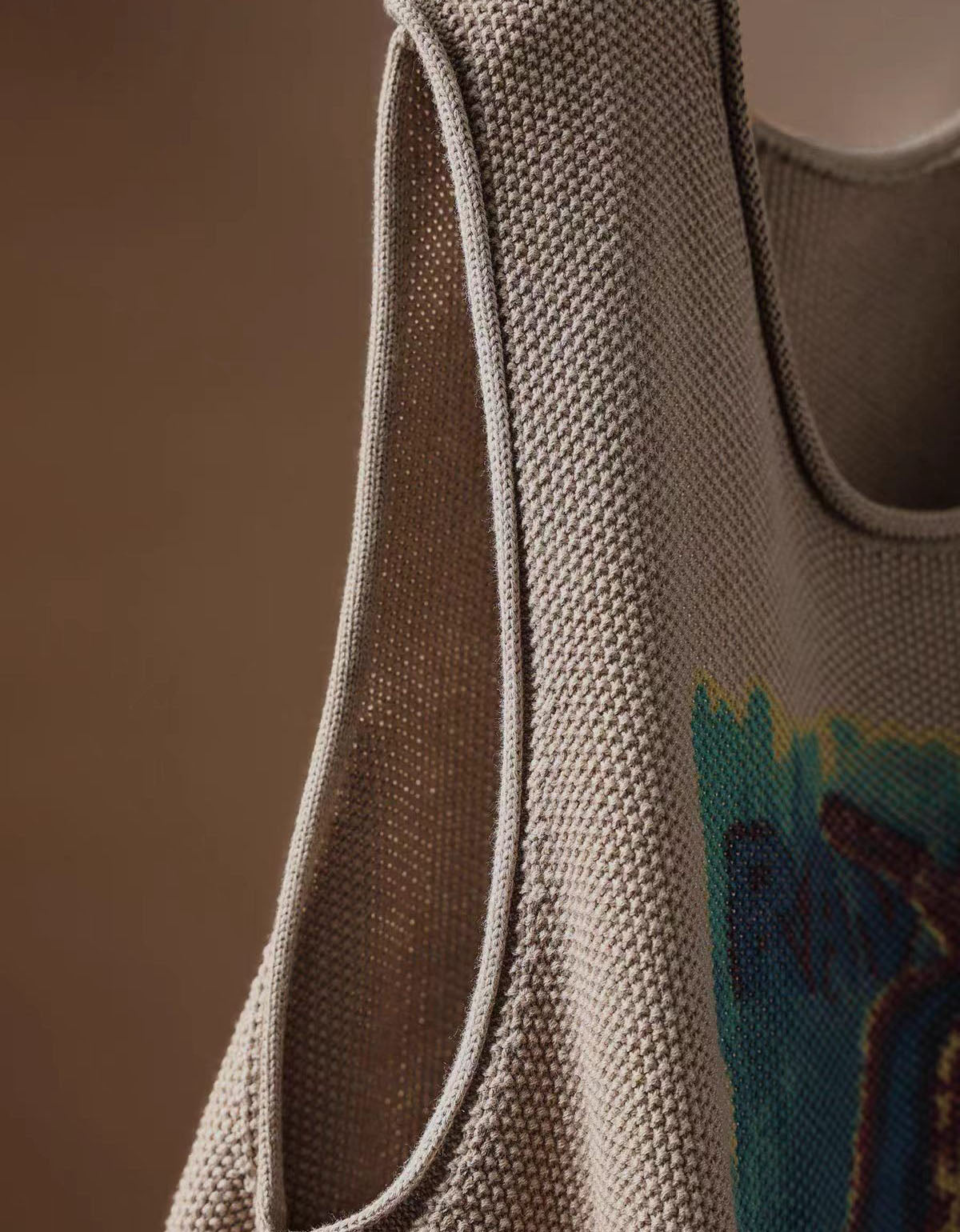 Women's taupe pear graphic sweater vest styled with a white blouse and dark casual trousers
