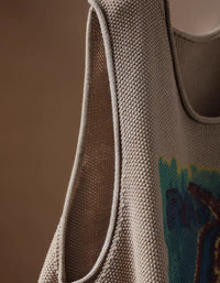 Women's taupe pear graphic sweater vest styled with a white blouse and dark casual trousers