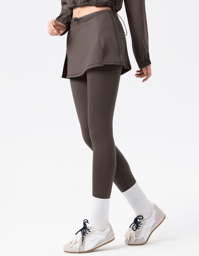 Person wearing a brown outfit with leggings and a jacket on a white background